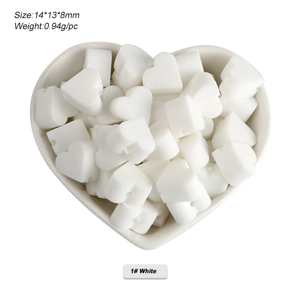 A small white bowl filled with silicone crown star heart beads for DIY jewelry making