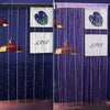 A close-up of a crystal beaded string curtain for a doorway, featuring purple and blue strands with decorative panels.