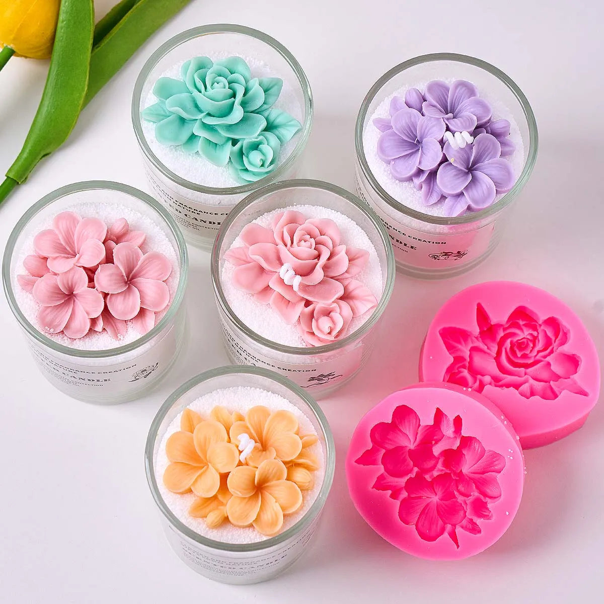 A collection of silicone molds in various shades of pink, purple, and green for making candles and soaps.