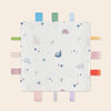A white baby sensory tag comfort blanket featuring various pastel-colored animal and floral patterns.