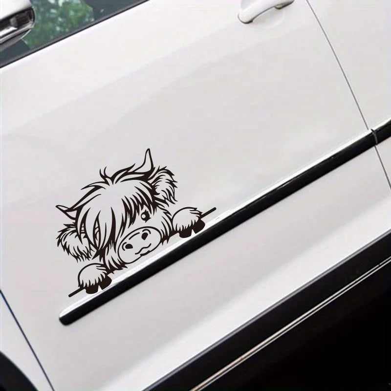 A black vinyl sticker of a cow's head peeking out from a white car door.
