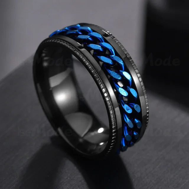 A close-up of a stainless steel spinner ring with a blue braided design on a black background.