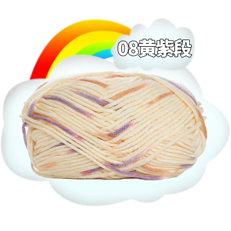 A ball of light beige milk cotton blend yarn with purple accents is shown next to a rainbow graphic.