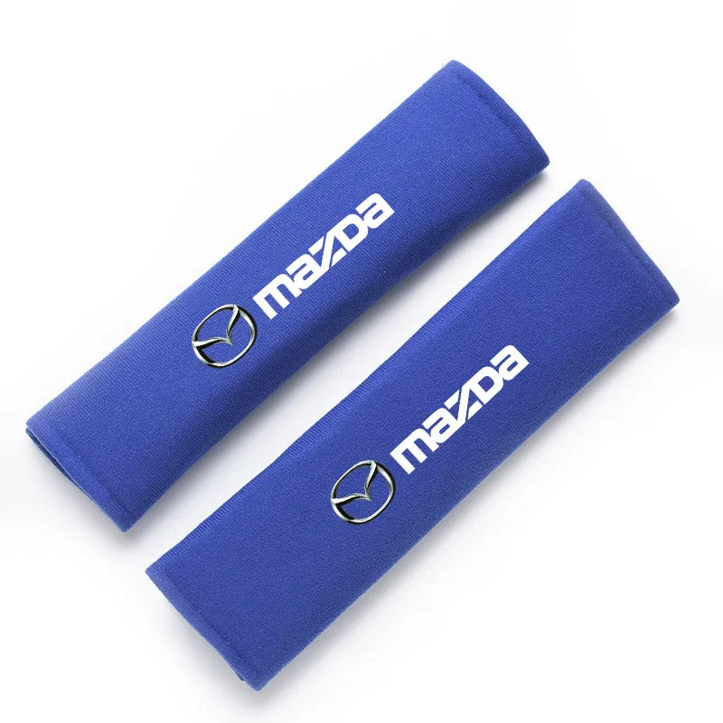 A royal blue soft cotton car seat belt shoulder protector cover with a silver Mazda logo.
