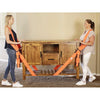 Two women demonstrate adjustable furniture moving straps with shoulder pads on a wooden table.