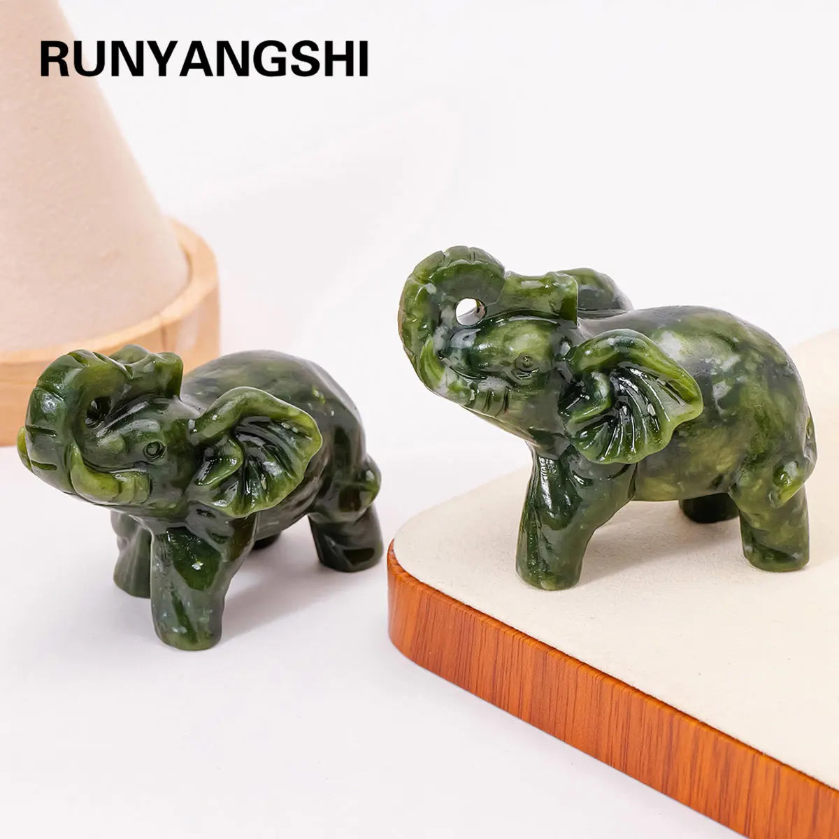 Hand-carved natural jade elephant statue in green on a light wooden base