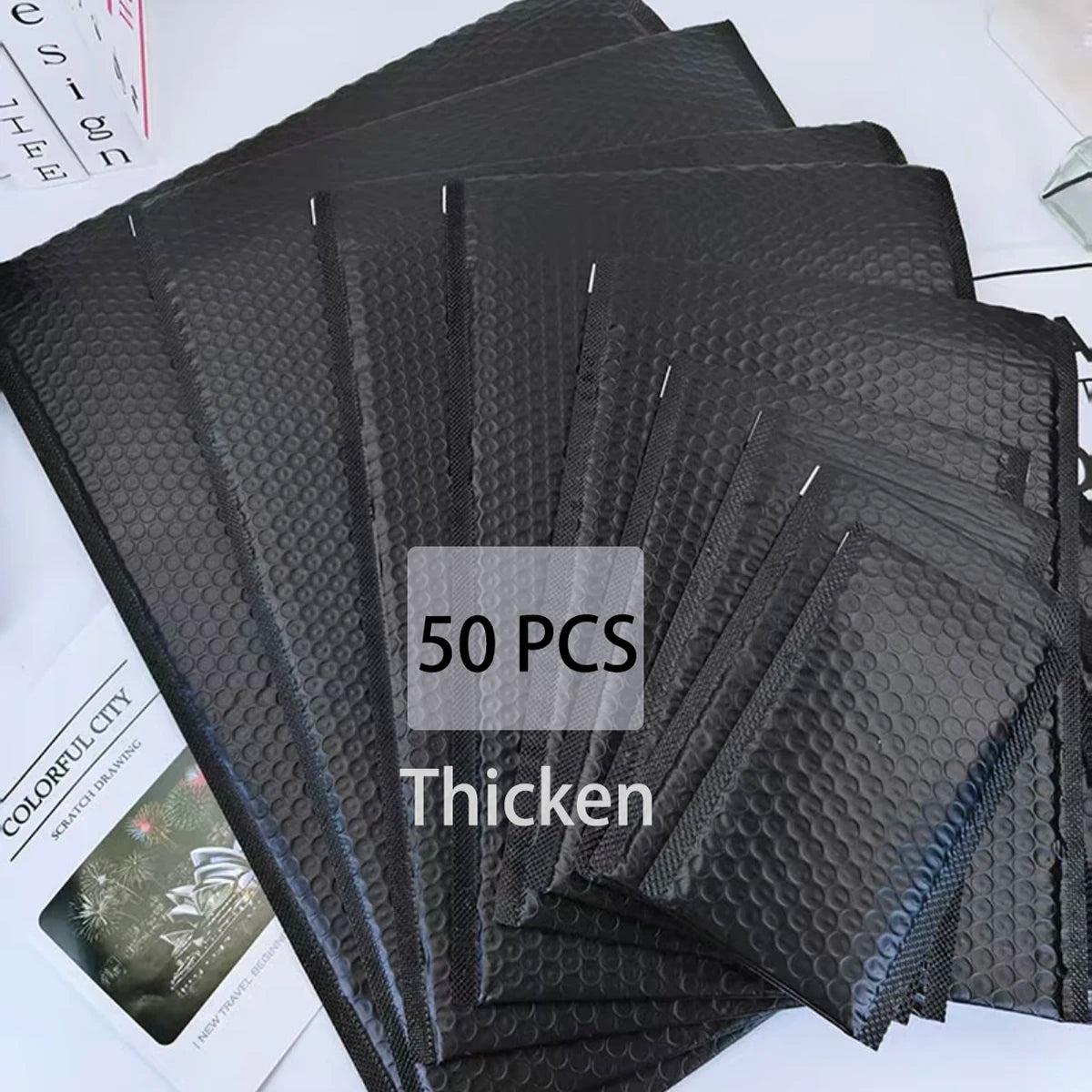 A stack of 50 black opaque bubble mailers with self-sealing adhesive.
