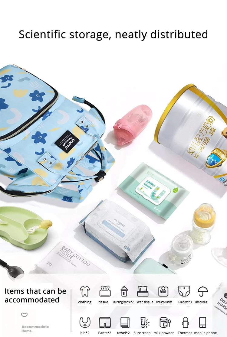 A blue and yellow waterproof diaper bag backpack with straps is shown alongside various baby care items like tissues, bottles