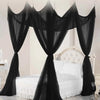 Black sheer lace canopy mosquito net draped over a white bed frame