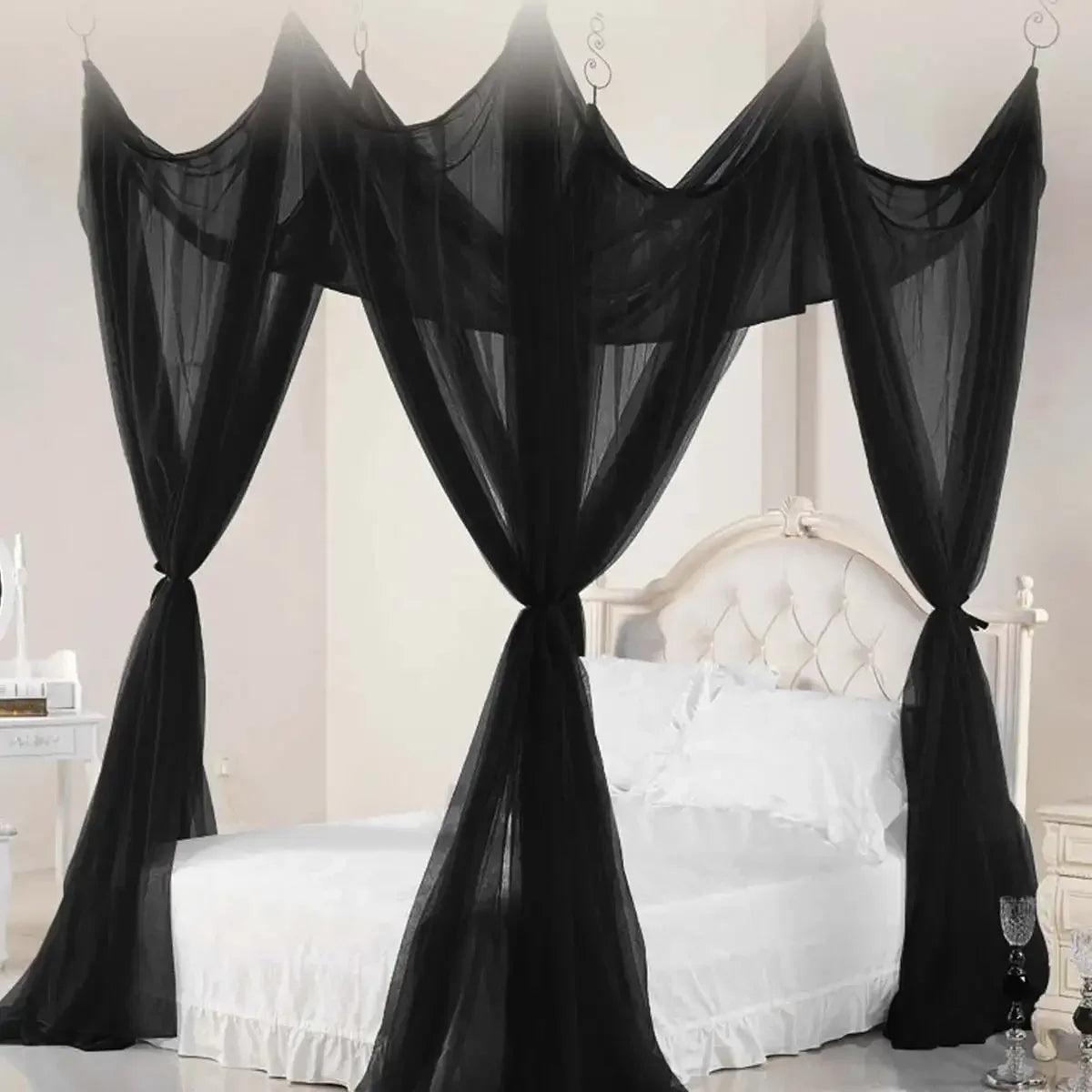 Black sheer lace canopy mosquito net draped over a white bed frame