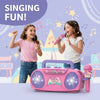 Two girls singing into a pink karaoke machine with light effects and microphones.