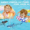 Two children floating in a pool with inflatable rings and remote control shark toys