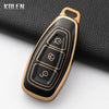 A gold-toned silicone car key fob cover with a black finish, shown against a dark background.