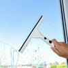 A hand is using a white squeegee replacement rubber blade to clean water spots on a window.