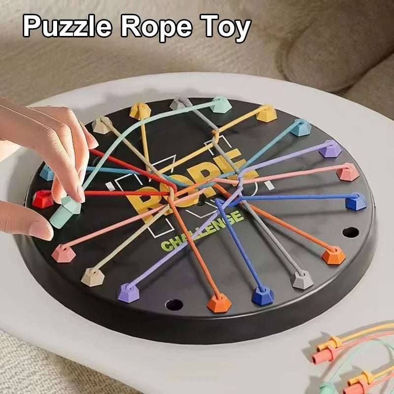 A black puzzle rope toy with colorful ropes arranged in a star pattern on a white surface.