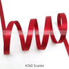 A roll of solid scarlet satin ribbon shown in a wavy pattern against a white background.