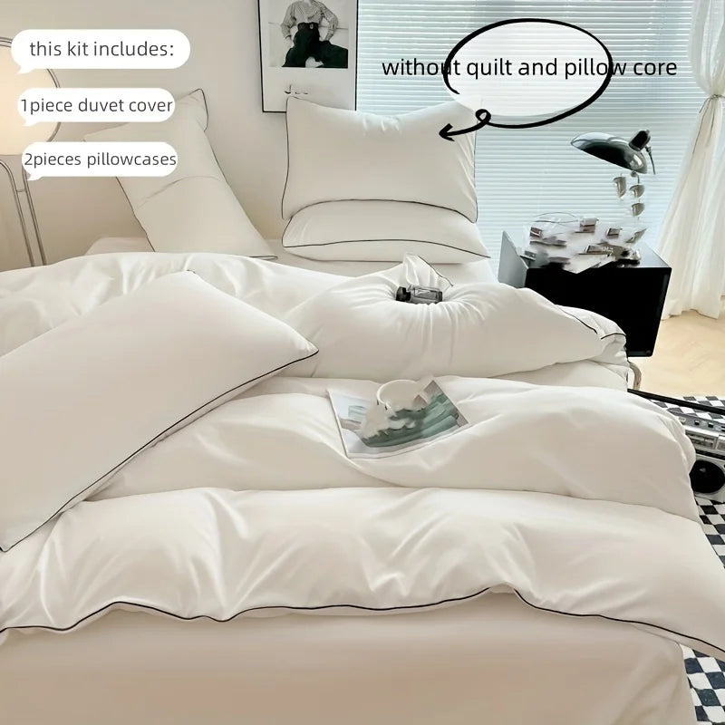 A white duvet cover set with pillowcases and a decorative pillow in a bedroom setting.