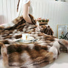 A brown and beige gradient bubble fleece throw blanket draped over a white surface.