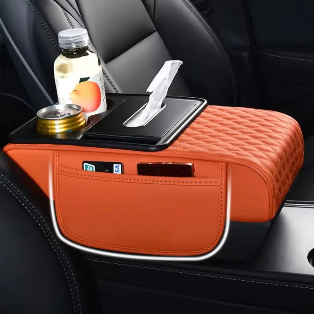 Orange car armrest cushion with storage and cup holders placed on a black car seat.