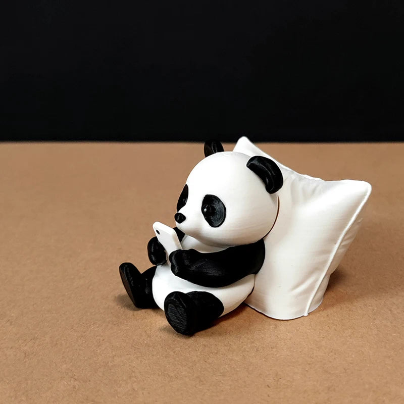 A white and black panda figurine sitting on a brown surface.