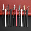 A collection of nine miniature metal katana replicas with various colored hilts and sheaths displayed on a brown leather back