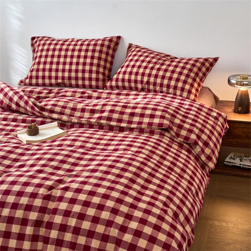 A close-up of a red and cream plaid duvet cover with a checkered pattern on a bed.