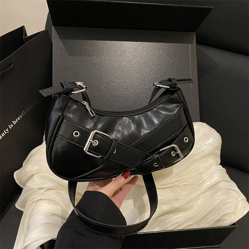 A black Y2K vintage PU leather crossbody bag is displayed in a box, resting on a white fabric surface.