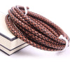 A coil of brown braided leather cord used for jewelry making, resting on a white surface.