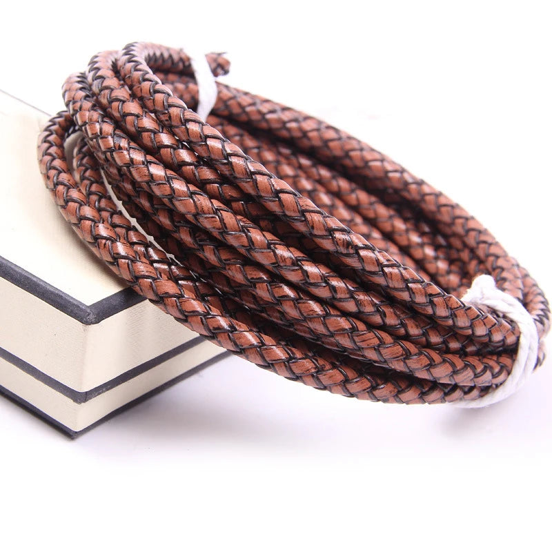 A coil of brown braided leather cord used for jewelry making, resting on a white surface.