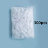 A white plastic bag filled with 300 disposable shower caps for hair protection and salon use.
