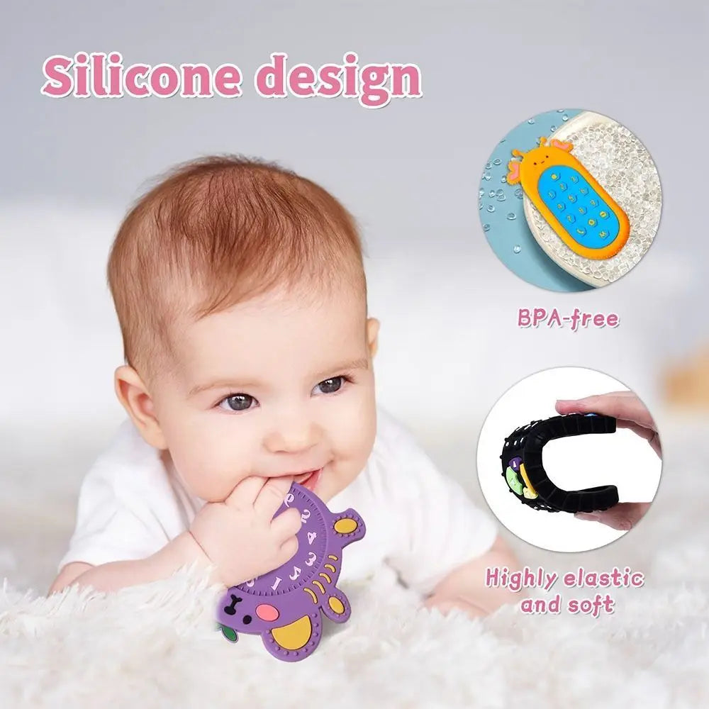 A baby is shown holding a purple silicone teether toy on a white fluffy surface.