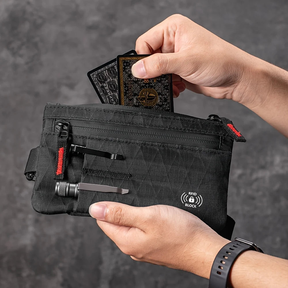 Une main tient un portefeuille de soirée noir anti-RFID et une carte de crédit.