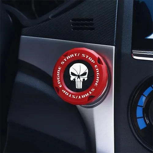Close-up of a red rotating protective cover for a car ignition start button featuring a skull design.