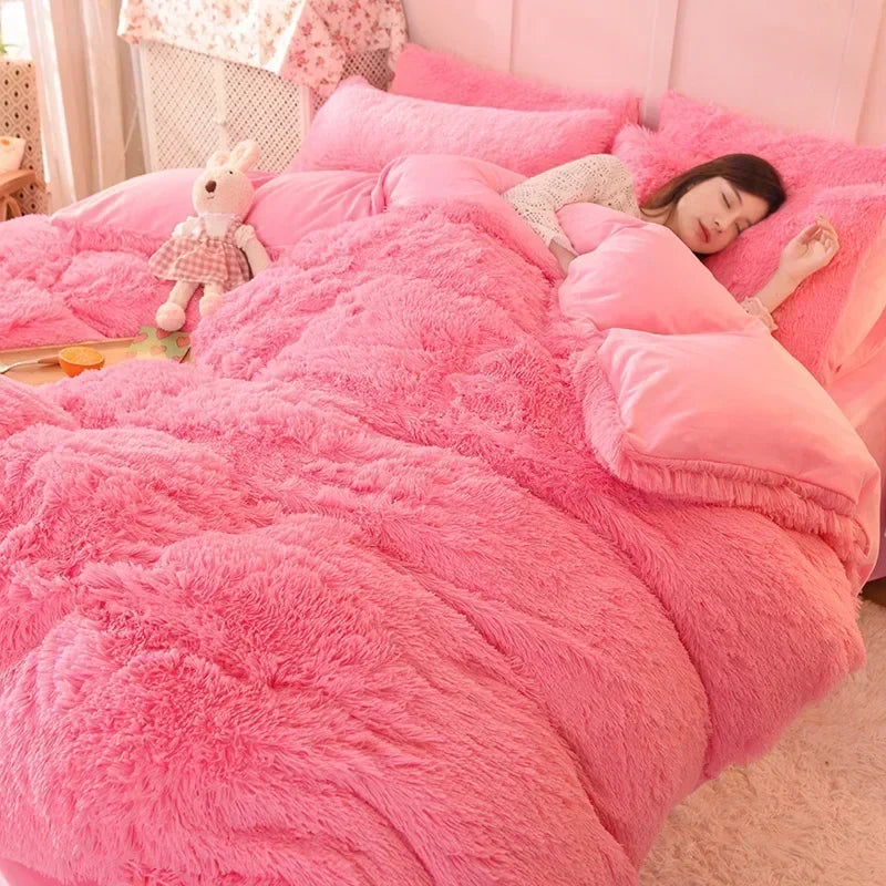 A pink plush mink velvet duvet cover set with sheets featuring a white stuffed animal on the bed.