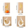 A set of Nordic ceramic sculptures featuring golden leaves on white and orange bases.