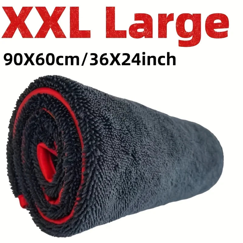 A rolled black microfiber car drying towel with red accents.