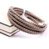 A coil of genuine braided leather cord in brown and black tones, used for jewelry making.