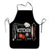 Black apron with white text that reads Bless this kitchen and enjoy the delicious food