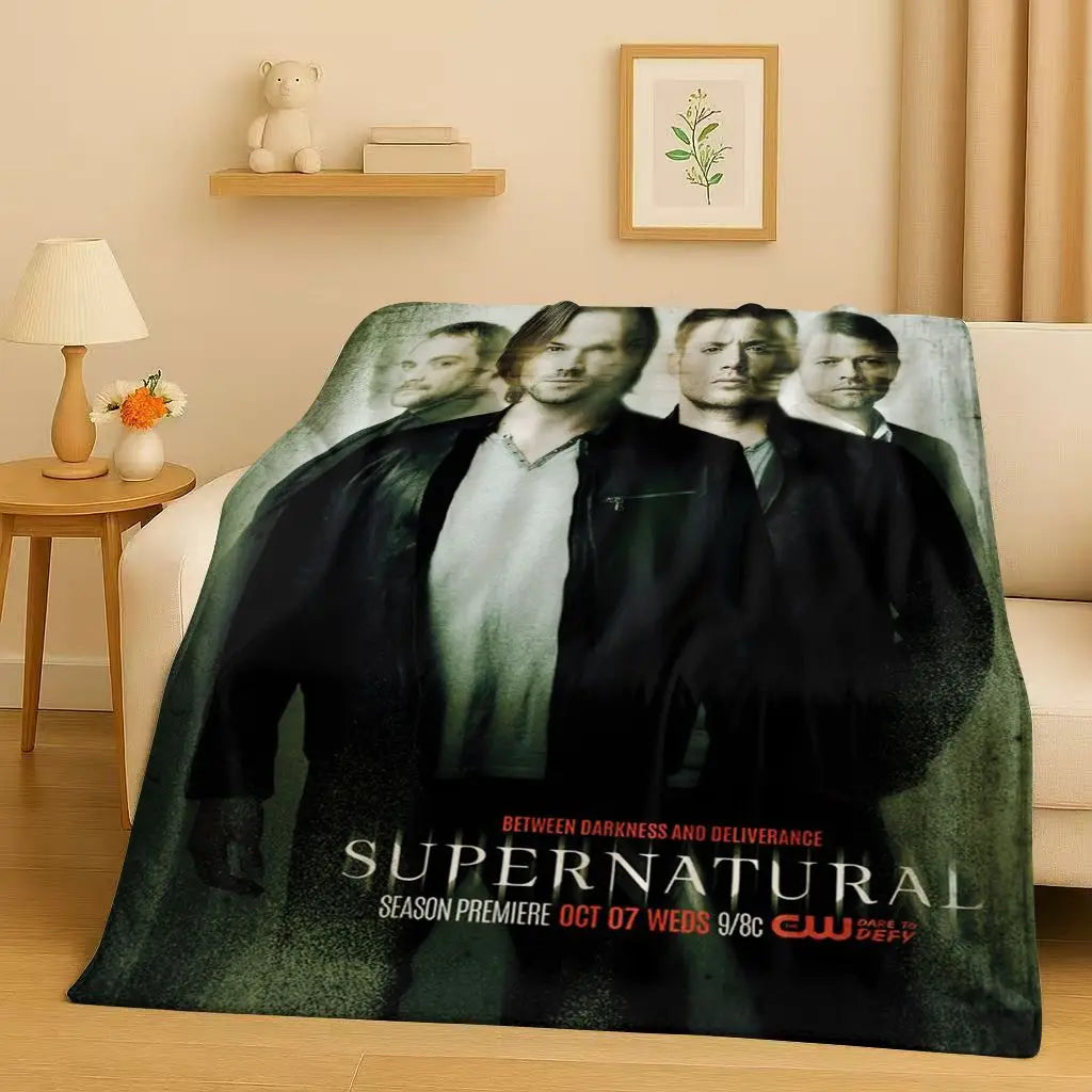 A dark green blanket featuring a collage of characters from the Supernatural TV show with the title text.