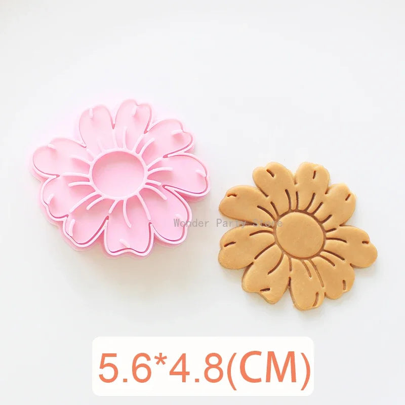 A set of three pink and orange floral cookie cutters featuring cherry blossom, peach blossom, and sunflower designs.