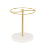 A gold-colored sunglasses organizer stand with a circular hoop and a wooden base.