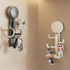A silver suction cup hook with a rotating head is mounted on a wall, featuring various hooks and accessories.