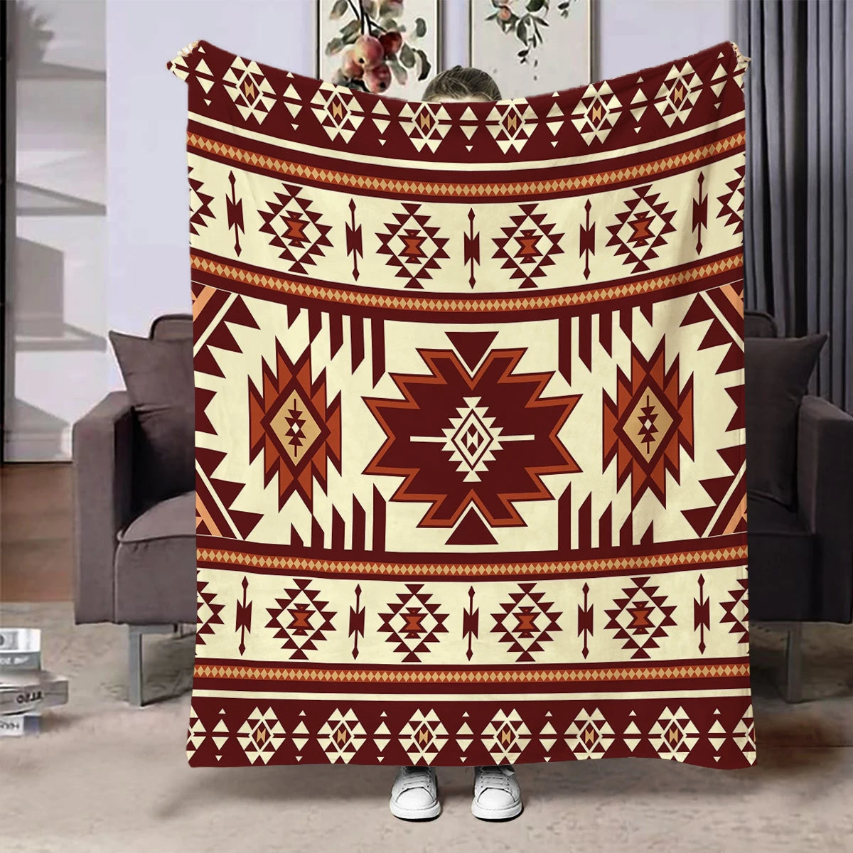 A patterned flannel throw blanket featuring geometric ethnic designs in shades of brown and cream.