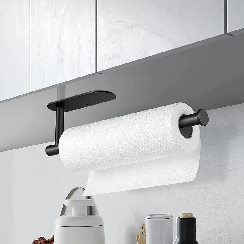A white paper towel roll is mounted on a black wall-mounted holder above a kitchen counter.