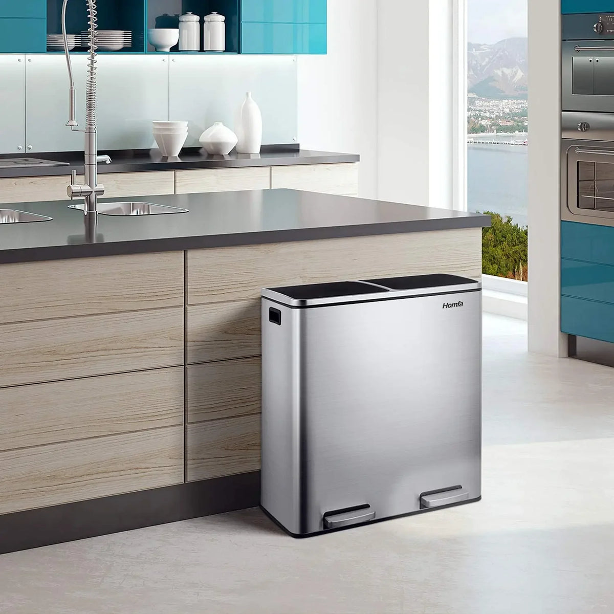 A stainless steel dual compartment recycling trash can with a soft-close lid sitting on a kitchen counter.