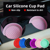 A collection of pink and colored silicone cup pad coasters with rhinestone accents shown in a car cup holder.