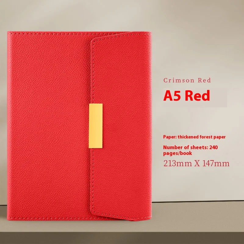 A red A5 journal notebook with a stitched cover and a yellow spine is displayed on a light background.