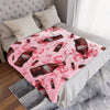 A pink Dr. Pepper ultra-soft printed throw blanket is draped over a white bed with a light gray textured throw.