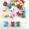 A collection of 10 mixed alphabet letter beads in various colors like pink, red, yellow, green, and blue scattered on white f