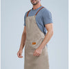 A man wearing a beige waterproof kitchen apron over a gray t-shirt.